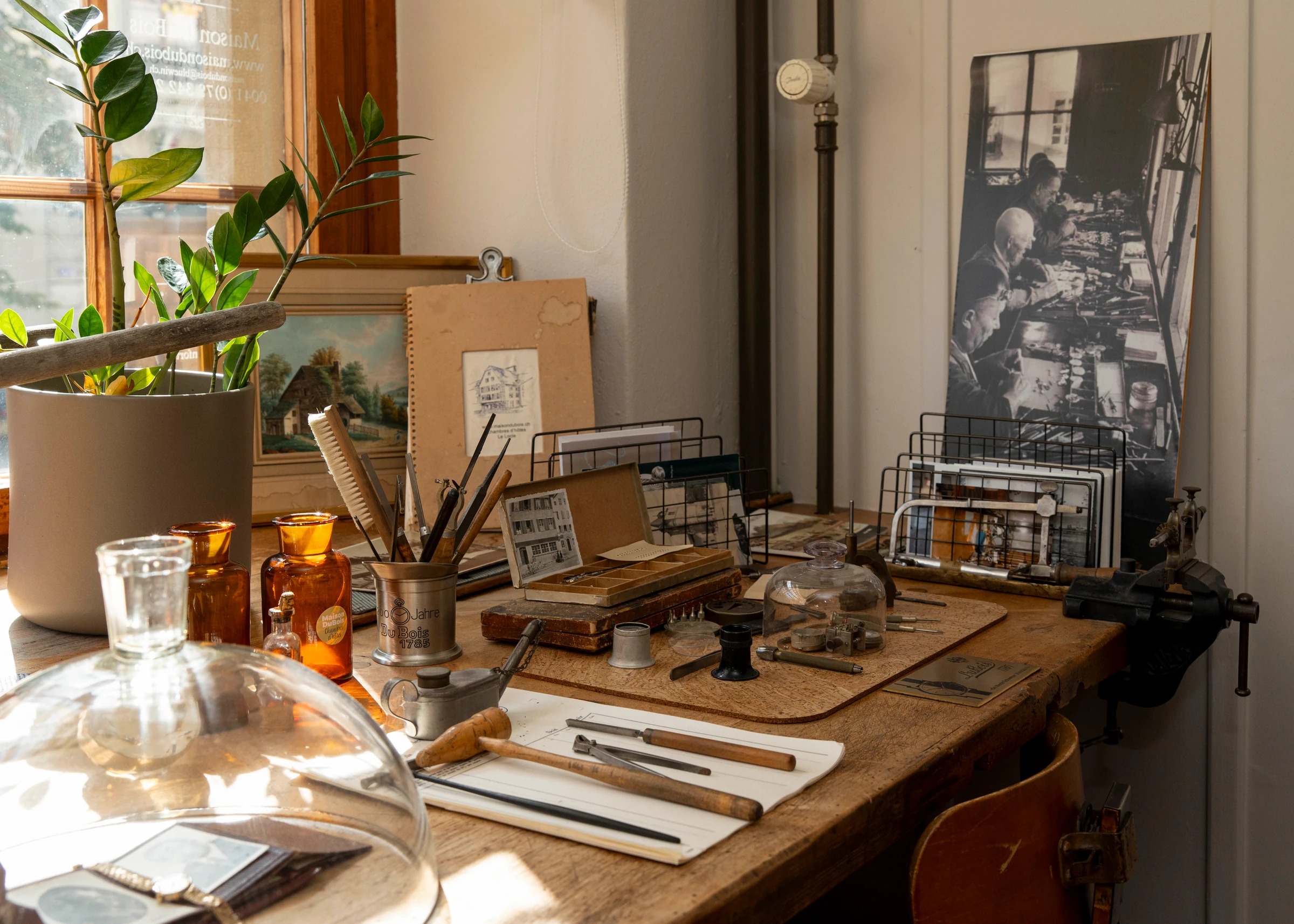 L’établi de la Maison DuBois, ses outils et une photographie d’horlogers au travail