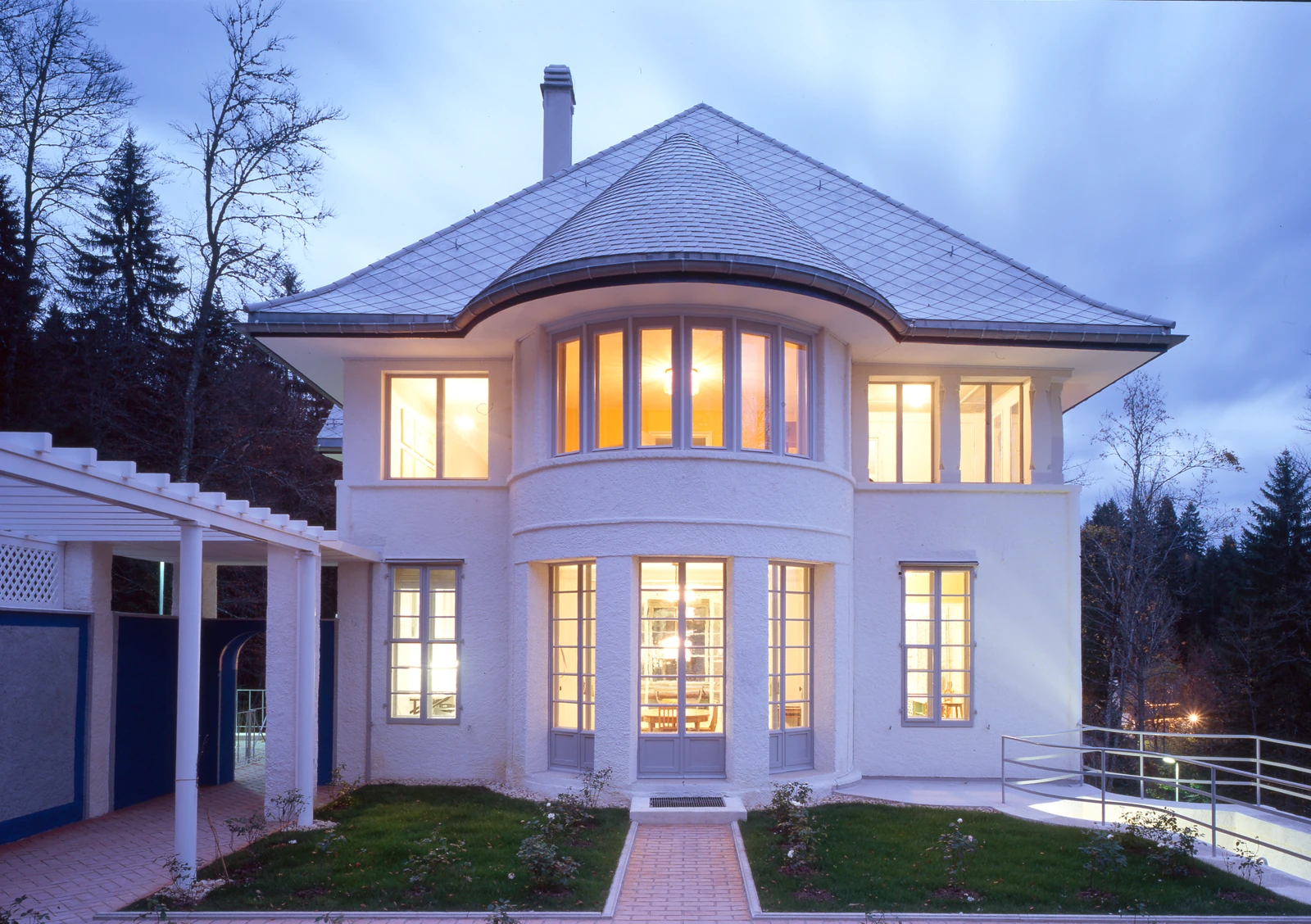 La façade ouest de la Maison blanche, ses fenêtres éclairées au crépuscule